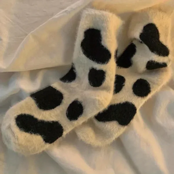 une des deux paires de chaussettes vache sur un lit
